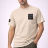 Man wearing the Ruffus Slate T-Shirt. Beige T-shirt with Ruffus Slate Design on the left chest
